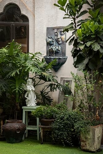 Tranquil garden corner with statue and wall art surrounded by plants
